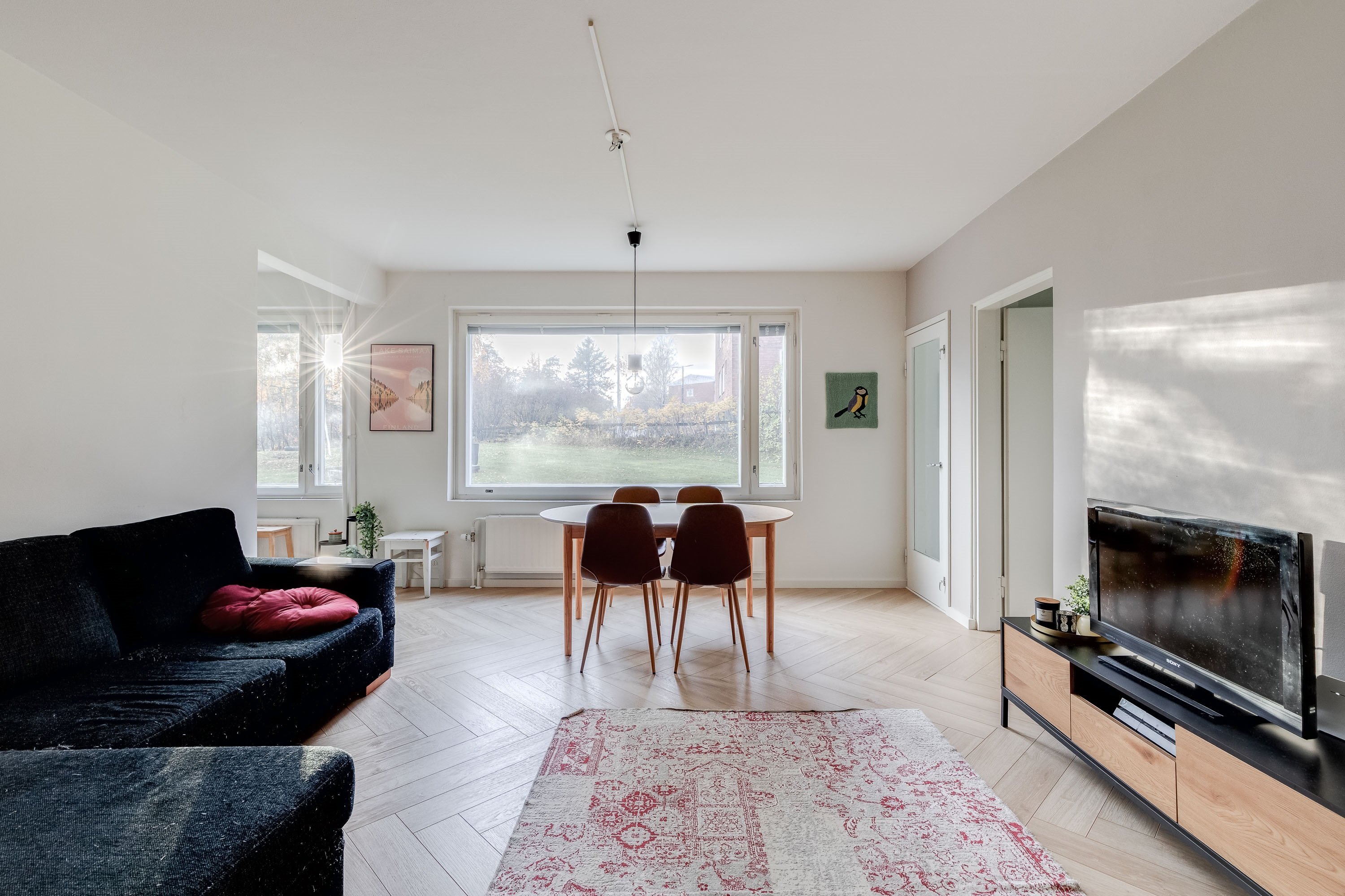 Syyspäivän valo suorastaan tulvii olohuoneen valtavasta ikkunasta,