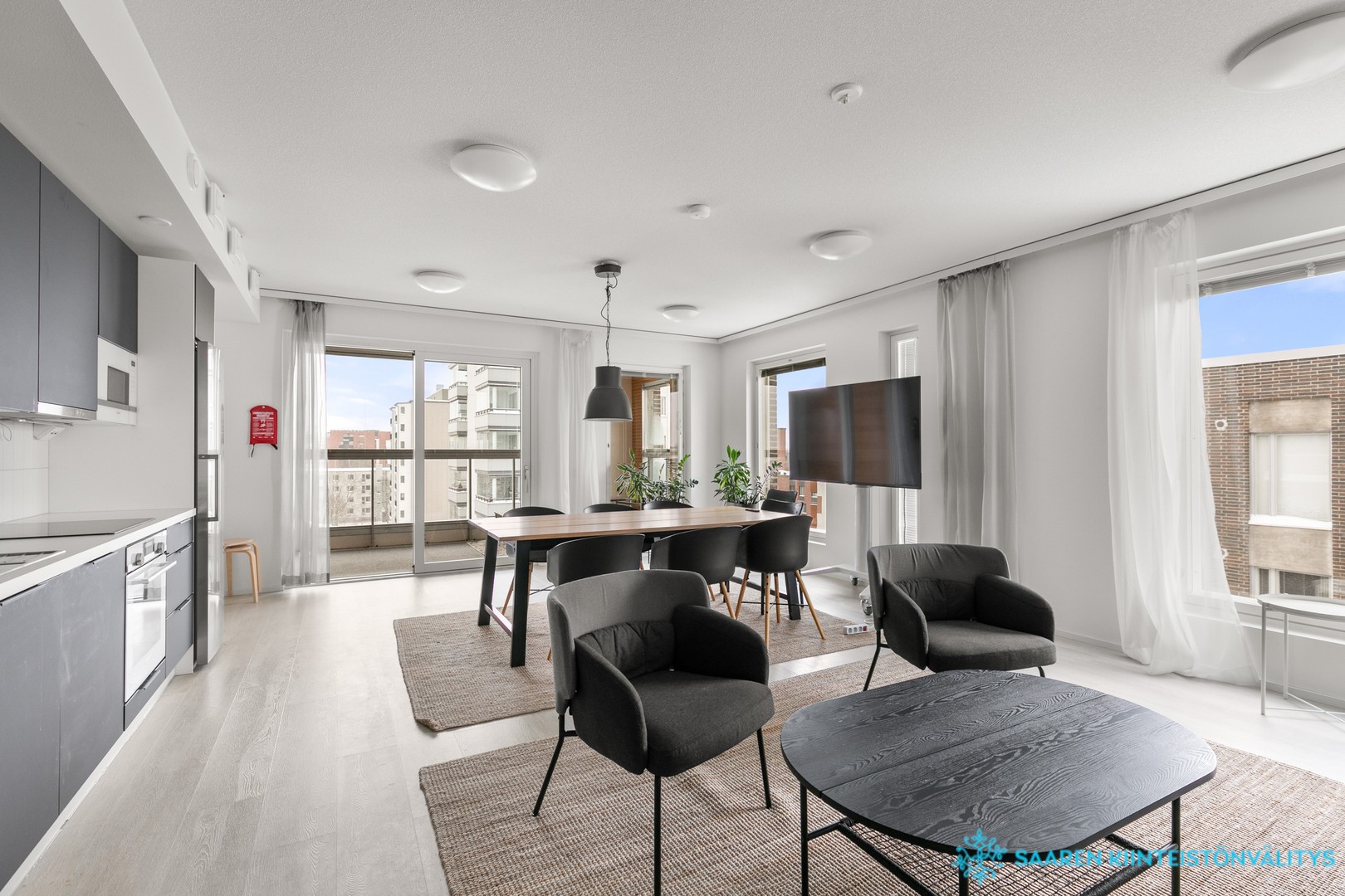 Taloyhtiön 7. kerroksen kerhohuone jossa oleskelutila keittiöllä ja parvekkeella